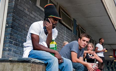 A group of young adults sitting outside of a building